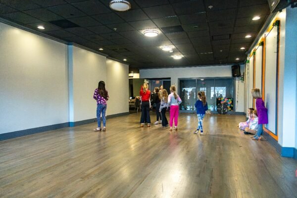 Kids aged 3 and up participating in a free trial dance class at Moonlight Ballroom Dance Studio, learning dance techniques in a bright, welcoming studio environment