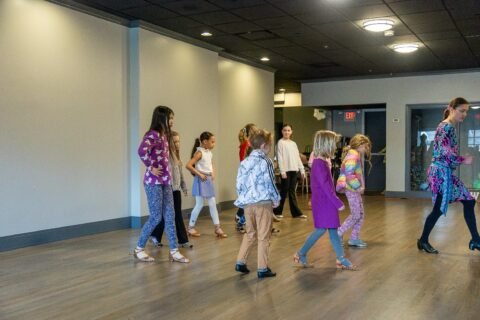 Kids aged 3 and up participating in a free trial dance class at Moonlight Ballroom Dance Studio, learning dance techniques in a bright, welcoming studio environment